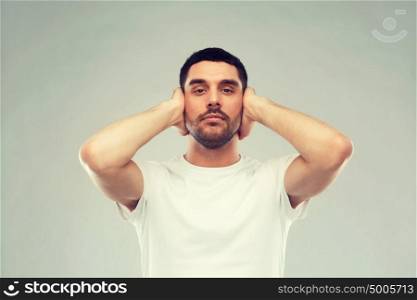problem, emotion, stress, hearing problem and people concept - latin man covering his ears with hand palms. latin man covering his ears with hand palms