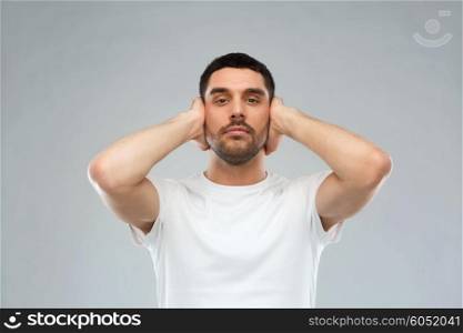 problem, emotion, stress, hearing problem and people concept - latin man covering his ears with hand palms