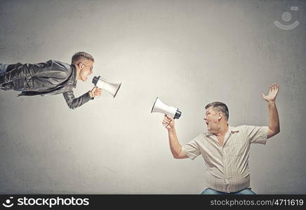 Problem of generation conflict. Young man and elder one screaming aggressively in megaphone on each other