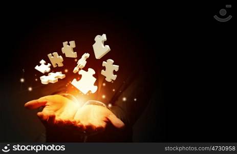Problem solving . Close up of businessman holding jigsaw elements in palm