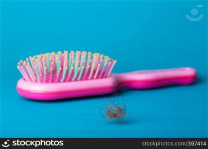 problem with hair. pink comb and drop-down hair on a blue background