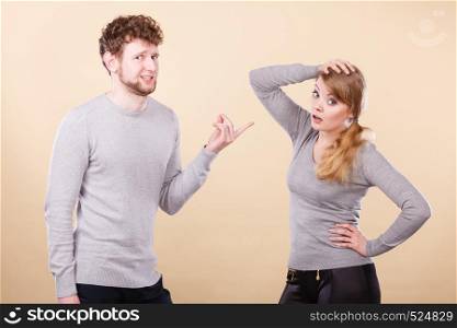 Problems in relationship. Young blonde couple arguing and yelling on each other. Emotional way to express bad feelings.. Young emotional couple arguing.