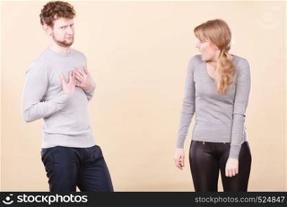 Problems in relationship. Young blonde couple arguing and yelling on each other. Emotional way to express bad feelings.. Young emotional couple arguing.