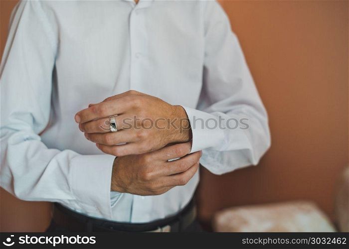 Process of clothing of a shirt.. The young man dresses cuff links on a shirt 2231.. The young man dresses cuff links on a shirt 2231.
