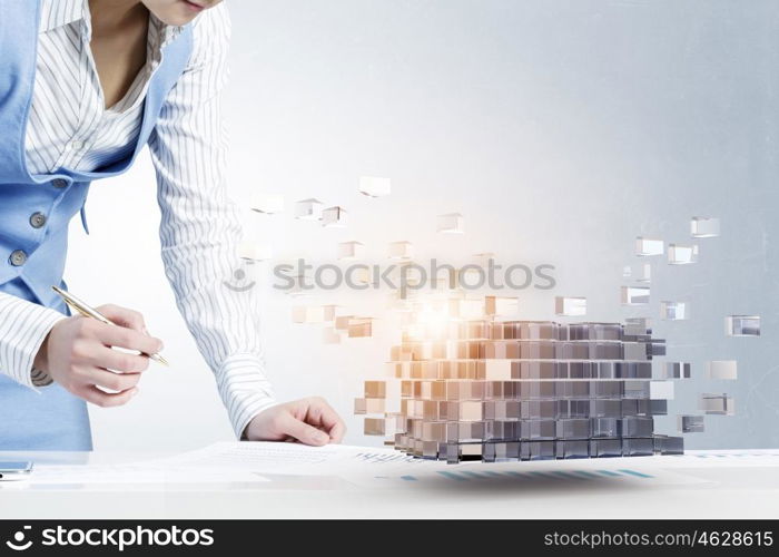 Process of new technologies intergration . Close up of business person writing with pen and digital cube figure on papers