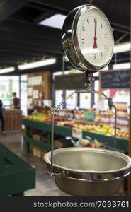 Produce scale in supermarket with people in background