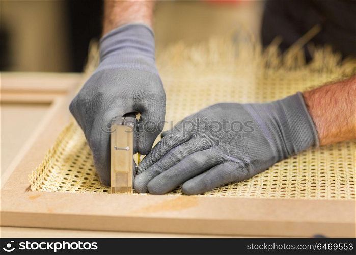 production, manufacture and industry concept - assembler with staple gun making furniture. assembler with staple gun making furniture