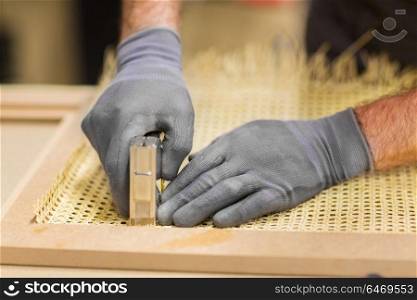 production, manufacture and industry concept - assembler with staple gun making furniture. assembler with staple gun making furniture