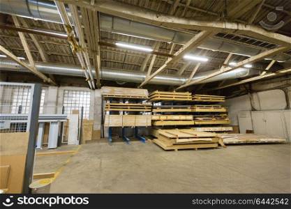production, manufacture and woodworking industry concept - boards storing at factory warehouse. boards storing at woodworking factory warehouse