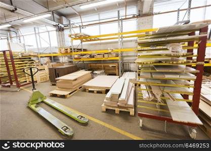 production, manufacture and woodworking industry concept - boards storing at factory warehouse. boards storing at woodworking factory warehouse