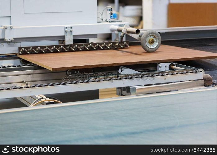 production, manufacture and woodworking industry concept - chipboards processing on conveyer at furniture factory workshop. chipboards on conveyer at furniture factory