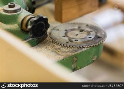 production, manufacture and woodworking industry concept - cogwheel of old machine at workshop. cogwheel of old machine at workshop