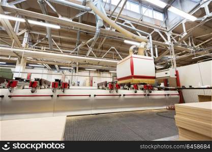 production, manufacture and woodworking industry concept - machine at furniture factory workshop. machine at woodworking factory workshop