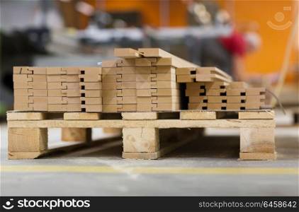 production, manufacture and woodworking industry concept - pallet of wooden boards or medium density fibreboards at workshop or storehouse. wooden boards or fibreboards at woodworking plant