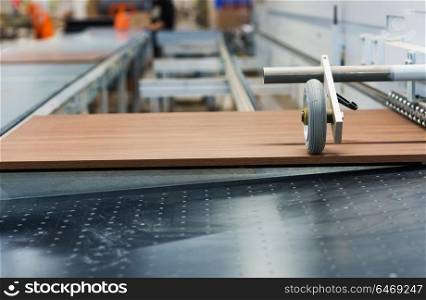 production, manufacture and woodworking industry concept - wooden board processing on conveyer at furniture factory workshop. wooden board on conveyer at furniture factory