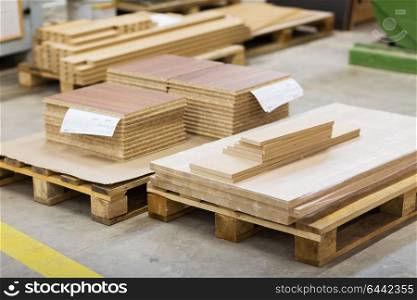 production, manufacture and woodworking industry concept - wooden boards and chipboards storing at furniture factory. wooden boards and chipboards storing at factory