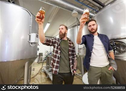 production, manufacture, business and people concept - men testing non-alcoholic or craft beer at brewery. men testing non-alcoholic craft beer at brewery