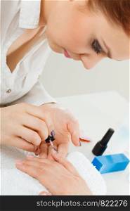 Profession and work. Beauty and health concept. Young professional woman beautician making nails to her female client. Manicurist focus on perfect result.. Female beautician making nails.