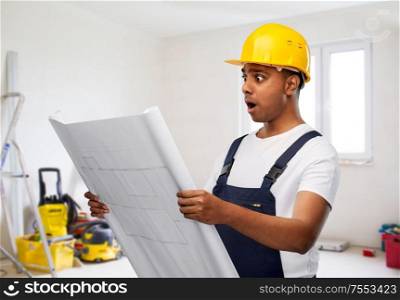 profession, building and repair concept - shocked indian builder or repairman in helmet with blueprint over empty room with construction equipment background. shocked indian builder in helmet with blueprint