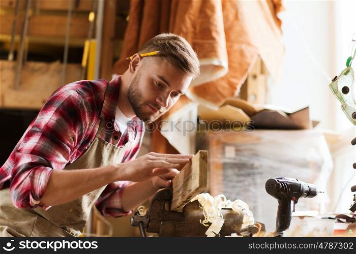 profession, carpentry, woodwork and people concept - carpenter testing wood plank evenness at workshop