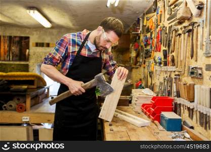 profession, carpentry, woodwork and people concept - carpenter with ax and wood plank working at workshop
