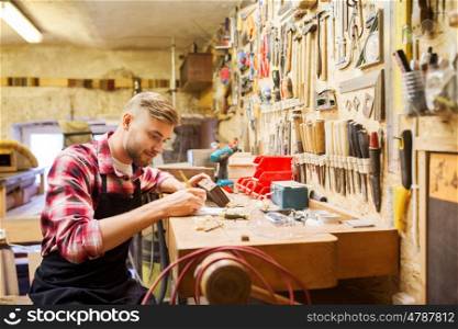 profession, carpentry, woodwork and people concept - carpenter with wood plank and notebook working at workshop