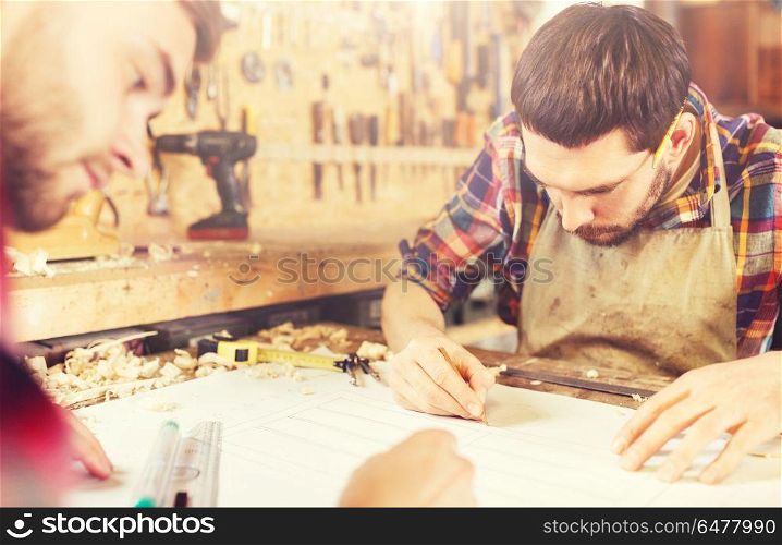 profession, carpentry, woodwork and people concept - two carpenters with ruler and blueprint at workshop. carpenters with ruler and blueprint at workshop. carpenters with ruler and blueprint at workshop