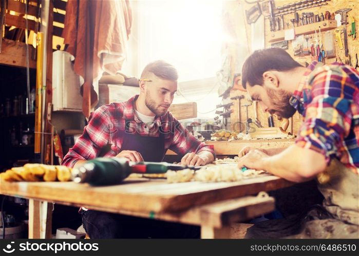 profession, carpentry, woodwork and people concept - two carpenters with ruler and blueprint at workshop. carpenters with ruler and blueprint at workshop. carpenters with ruler and blueprint at workshop
