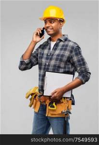 profession, construction and building - happy smiling indian worker or builder in helmet calling on smartphone over grey background. indian builder in helmet calling on smartphone