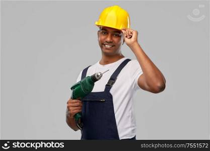 profession, construction and building - happy smiling indian worker or builder in helmet with electric drill or perforator over grey background. happy indian builder in helmet with electric drill