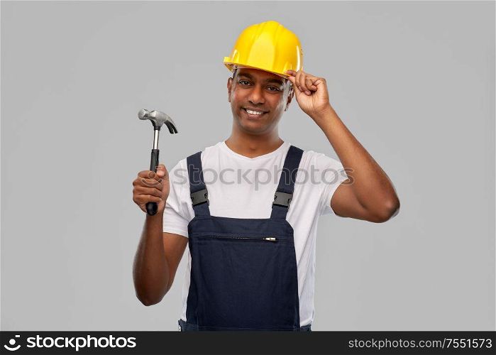 profession, construction and building - happy smiling indian worker or builder in helmet with hammer over grey background. happy smiling indian worker or builder with hammer