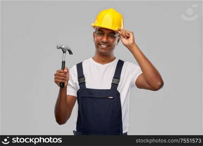 profession, construction and building - happy smiling indian worker or builder in helmet with hammer over grey background. happy smiling indian worker or builder with hammer