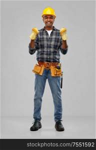 profession, construction and building - happy smiling indian worker or builder in helmet and gloves with tool belt over grey background. indian worker or builder in helmet and gloves