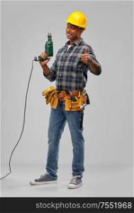 profession, construction and building - happy smiling indian worker or builder in helmet with electric drill or perforator over grey background. happy indian builder in helmet with electric drill