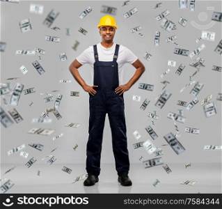 profession, construction and building - happy smiling indian worker or builder in helmet under money rain over grey background. happy smiling indian worker or builder in helmet