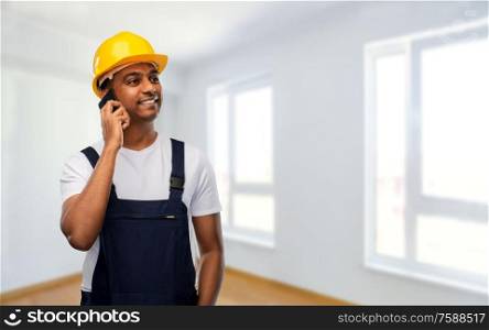 profession, construction and building - happy smiling indian worker or builder in helmet calling on smartphone over empty room at new home or apartment background. indian builder in helmet calling on smartphone