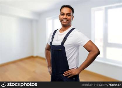 profession, construction and building - happy smiling indian worker or builder over empty room at new home or apartment background. happy smiling indian worker or builder