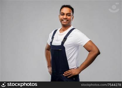 profession, construction and building - happy smiling indian worker or builder over grey background. happy smiling indian worker or builder