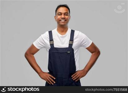 profession, construction and building - happy smiling indian worker or builder over grey background. happy smiling indian worker or builder
