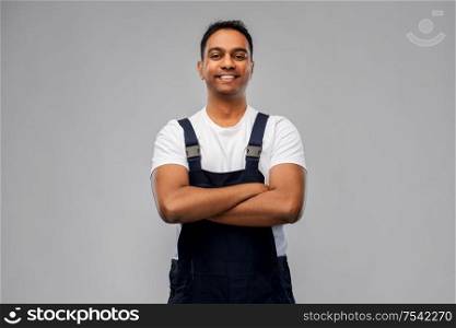 profession, construction and building - happy smiling indian worker or builder with crossed arms over grey background. happy indian worker or builder with crossed arms