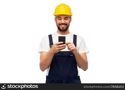 profession, construction and building - happy smiling male worker or builder in yellow helmet and overall with smartphone over white background. happy male worker or builder with smartphone