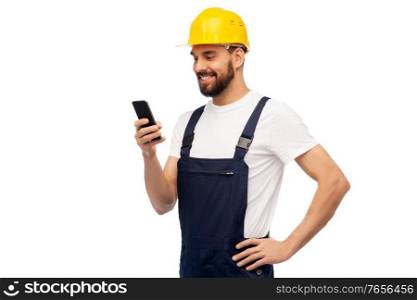profession, construction and building - happy smiling male worker or builder in yellow helmet and overall with smartphone over white background. happy male worker or builder with smartphone