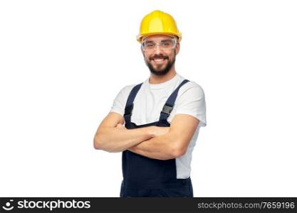 profession, construction and building - male worker or builder in yellow helmet and goggles with crossed arms over white background. male worker or builder with crossed arms