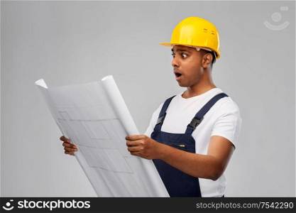 profession, construction and building - shocked indian builder in helmet with blueprint over grey background. shocked indian builder in helmet with blueprint