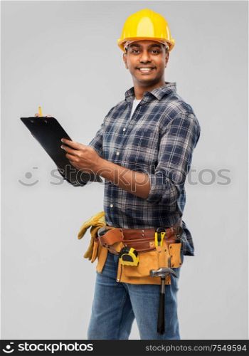 profession, construction and building - thinking indian worker or builder in helmet with clipboard and pencil over grey background. thinking builder with clipboard and pencil