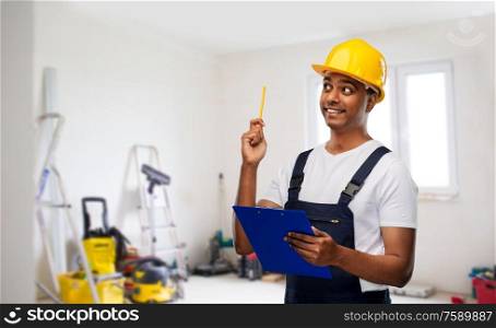 profession, construction and building - thinking indian worker or builder in helmet with clipboard and pencil having idea over room with working equipment at new home or apartment background. builder with clipboard and pencil having idea