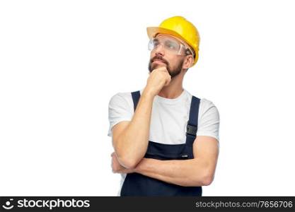 profession, construction and building - thinking male worker or builder in yellow helmet and goggles over white background. thinking male worker or builder with crossed arms