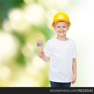 profession, future, childhood and people concept - smiling little boy in protective helmet with paint brush