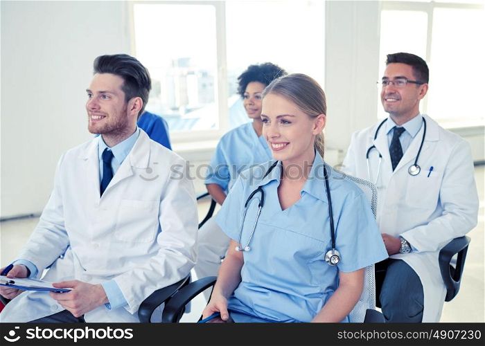 profession, medical education, health care, people and medicine concept - group of happy doctors on seminar in lecture hall at hospital. group of happy doctors on seminar at hospital