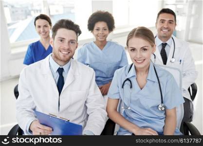 profession, medical education, health care, people and medicine concept - group of happy doctors on seminar in lecture hall at hospital